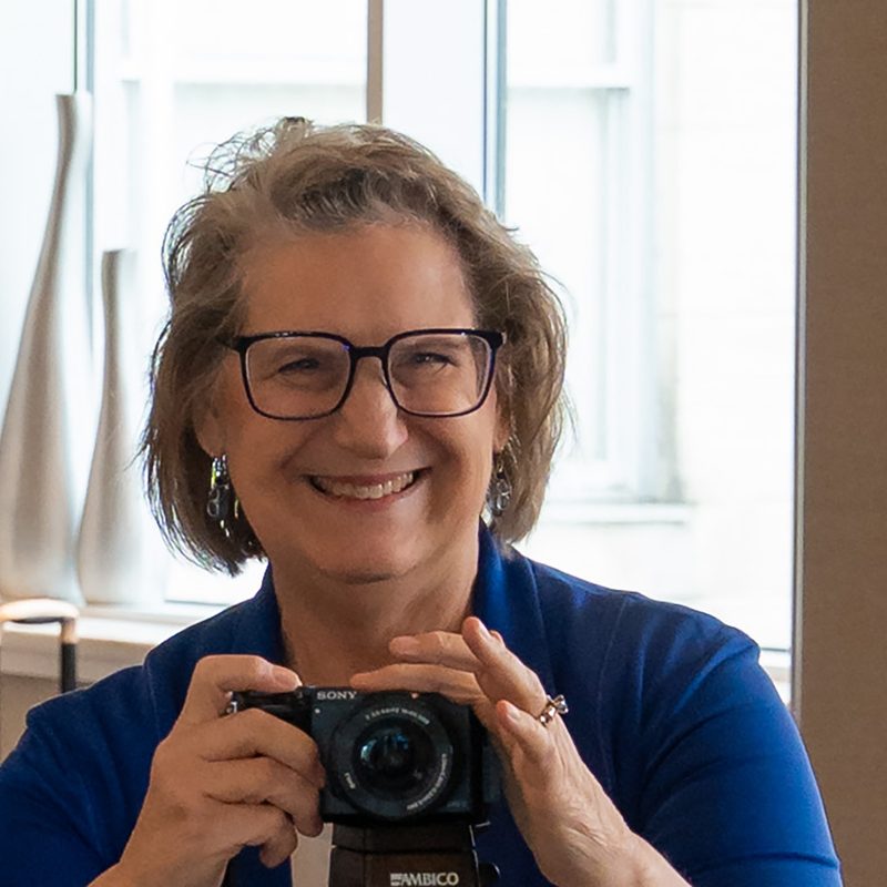 A woman with a camera taking photos of an event