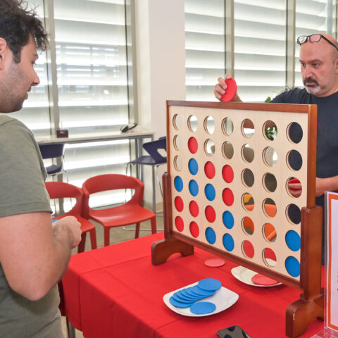 At a Weill Cornell Medicine-Qatar event, two colleagues participate in a game of strategy called Connect Four.