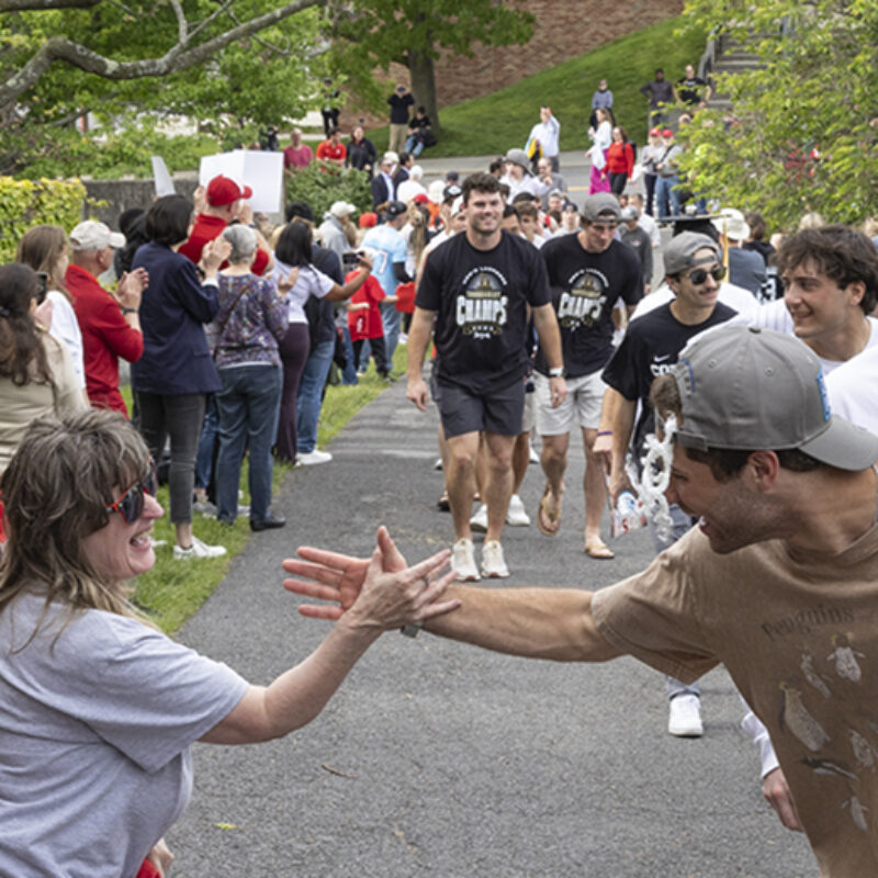 Fans line a sidewalk to greet and cheer returning championship team.