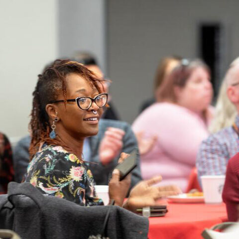 Several people at a table listen to announcements.