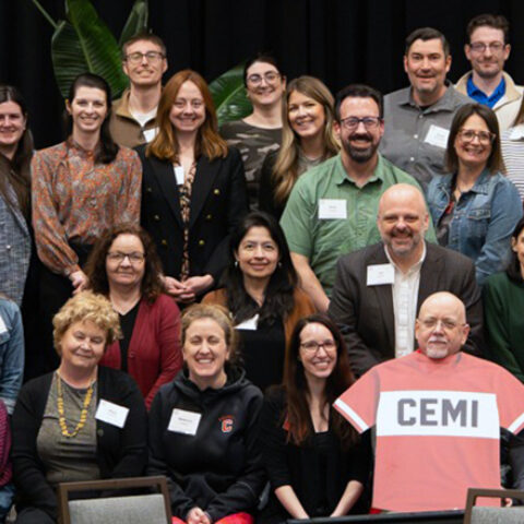a group of people pose with a CEMI jersey