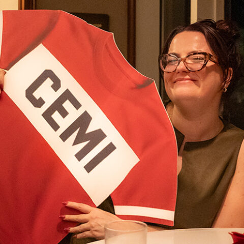 a woman holds a CEMI jersey cutout