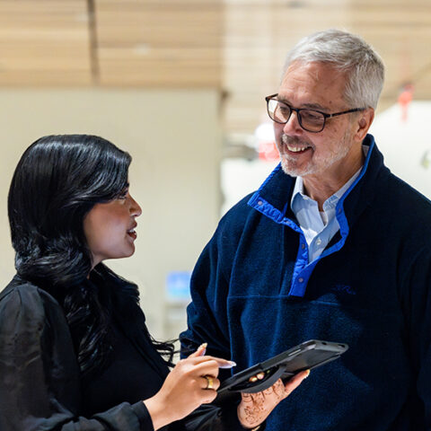 two colleagues discuss data on a tablet at WCM.